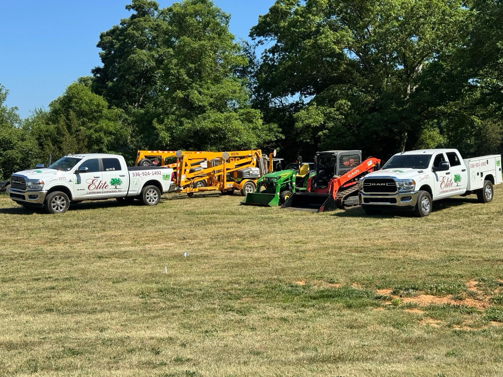 Elite Landscape Contractors trucks and equipment lined up in the field